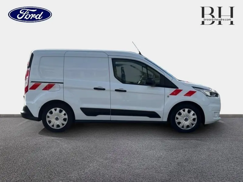 Vue de profil droit d'un Ford Transit Connect L1 blanc glacier avec bandes réfléchissantes rouges sur ailes avant et arrière.