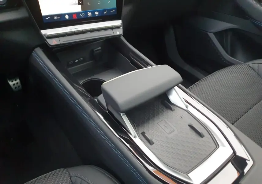 Vue rapprochée de la console centrale avec accoudoir et chargeur à induction du Renault Austral gris schiste.