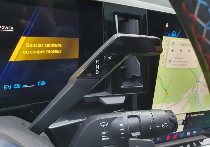 Gros plan sur la commande de boîte automatique et la manette d’essuie-glace du Renault Austral 2025, intérieur noir avec écran tactile.