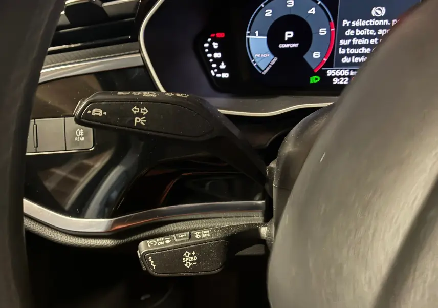 Gros plan sur les commandes au volant et tableau de bord numérique de l'Audi Q3 Sportback 2021, intérieur noir.