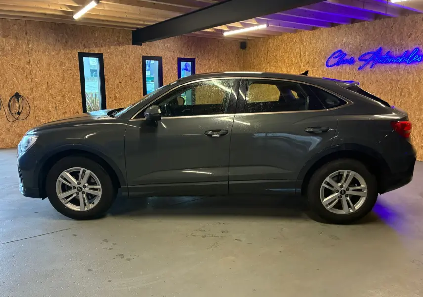 Audi Q3 Sportback gris en vue de profil côté gauche, avec jantes aluminium 17 pouces et intérieur visible par les vitres.