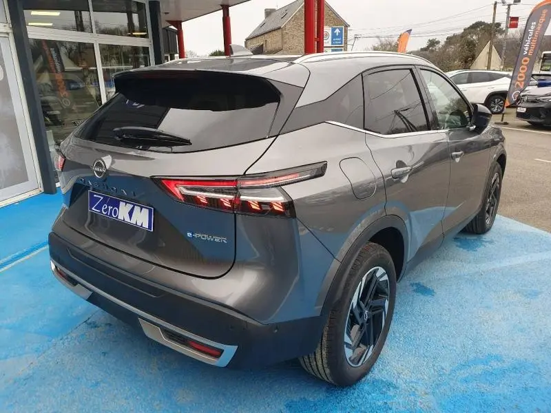 Vue 3/4 arrière droite du Nissan Qashqai Hybrid e-POWER gris métallisé avec feux arrière LED distinctifs.