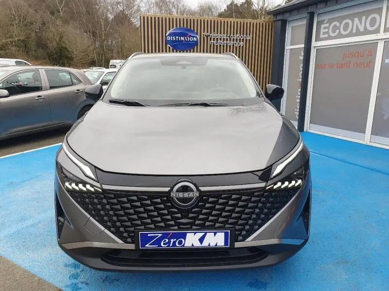 Vue avant d'un Nissan Qashqai Hybrid e-POWER gris Squale Métallisé avec calandre noire et feux LED distinctifs.
