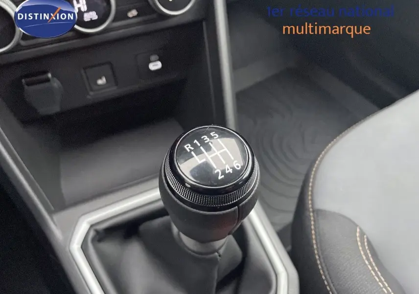 Gros plan sur le levier de vitesses manuel du Dacia Jogger gris schiste, avec partie du siège et console centrale visibles.