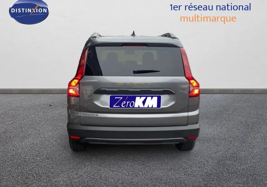 Vue arrière d'un Dacia Jogger gris schiste métal avec feux allumés sur fond neutre.