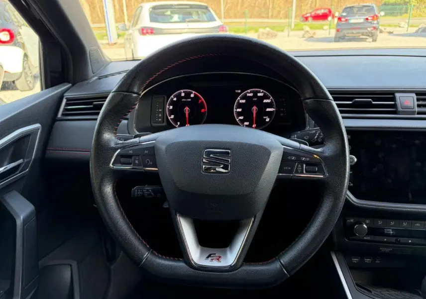 Vue intérieure centrée sur le volant noir du SEAT Arona 2020, avec logo FR et tableau de bord numérique visible.