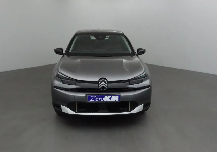 Vue frontale d'une Citroën C4 2025 gris Mercury et noir avec logo distinctif et plaque Zero KM.