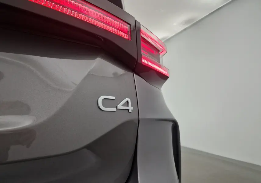 Gros plan sur l'arrière droit gris Mercury du Citroën C4 2025 avec feux arrière allumés et logo C4 visible.