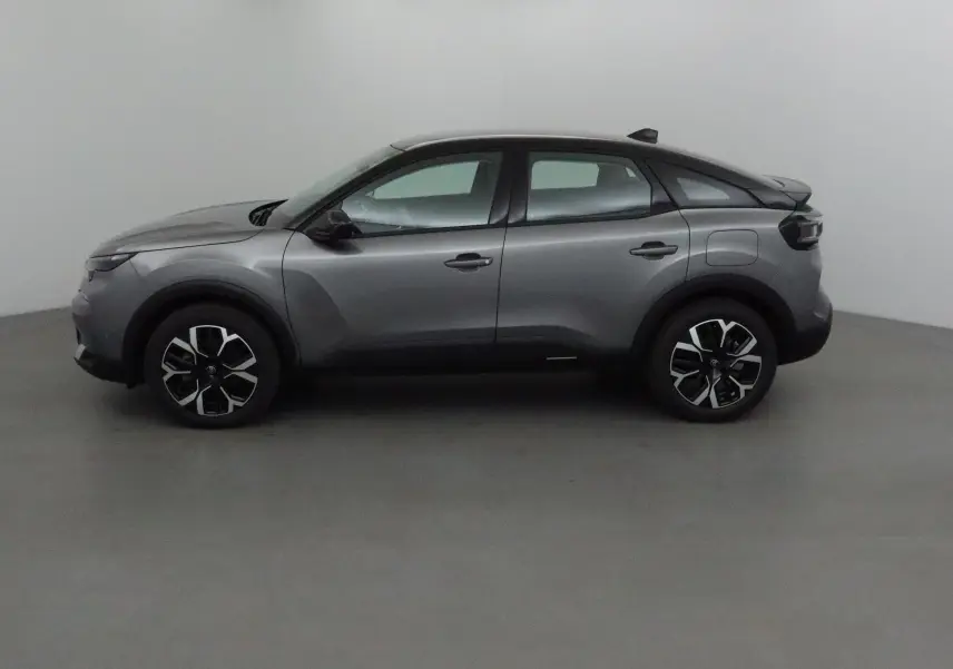 Profil côté gauche d'une Citroën C4 2025 gris Mercury avec toit noir et jantes alliage 18 pouces.