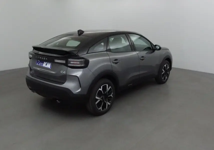 Vue 3/4 arrière droite d'une Citroën C4 2025 gris Mercury et noir avec jantes alliage noires et toit noir.