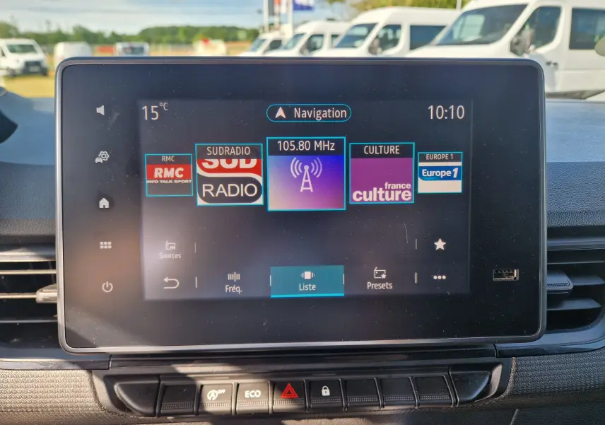 Écran tactile central du tableau de bord du Renault Kangoo blanc 2023 affichant les stations radio et la navigation.