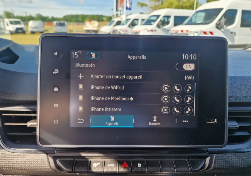 Gros plan sur l'écran tactile central du Renault Kangoo blanc 2023 affichant la connexion Bluetooth et la liste des appareils.