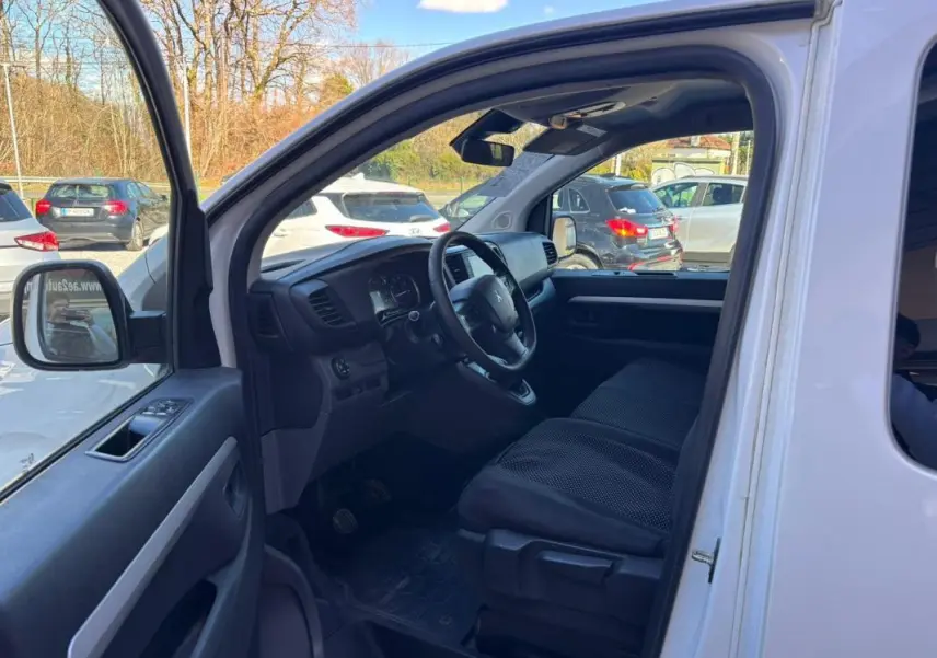Vue intérieure côté conducteur du Peugeot Expert Fourgon blanc 2018, montrant le tableau de bord et les sièges avant.