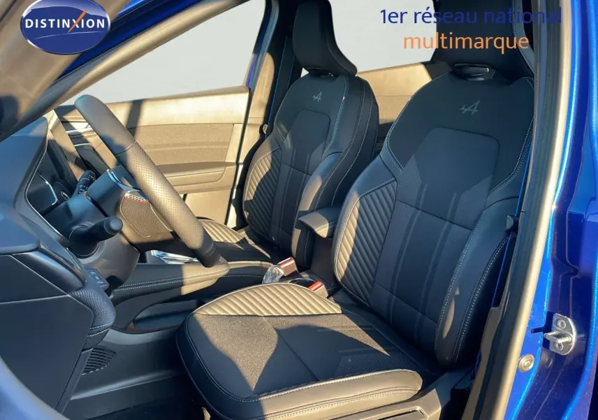 Intérieur avant du Renault Captur E-Tech hybride 2025 bleu Iron Metal, sièges noirs avec logo Alpine brodé.