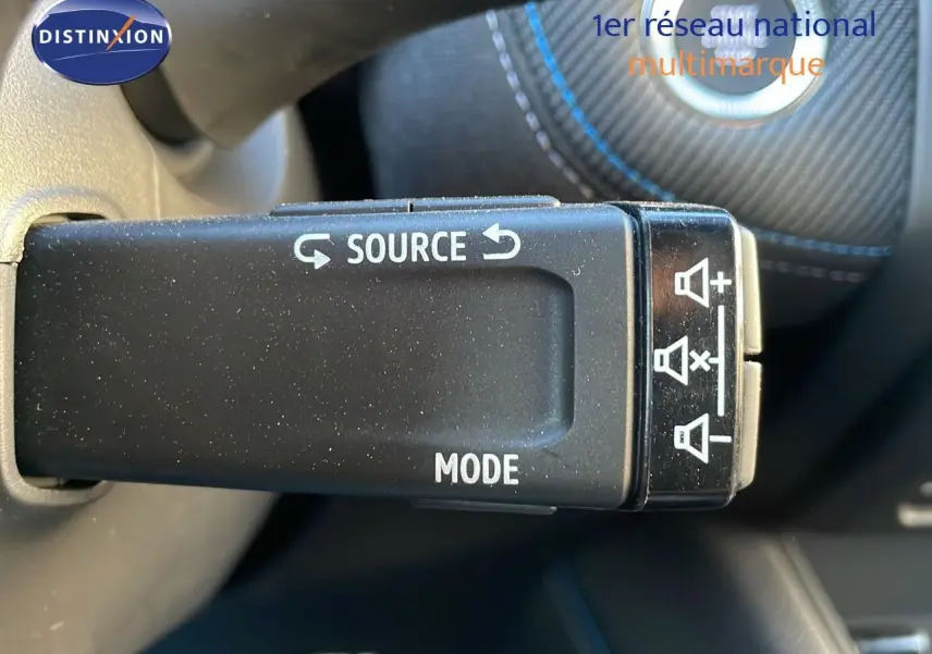 Gros plan sur la commande au volant du Renault Captur bleu Iron Metal, avec boutons source et mode visibles.