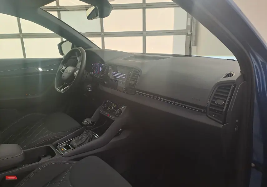 Intérieur côté conducteur du Skoda Karoq Bleu RS 2025 avec tableau de bord moderne et volant multifonction.