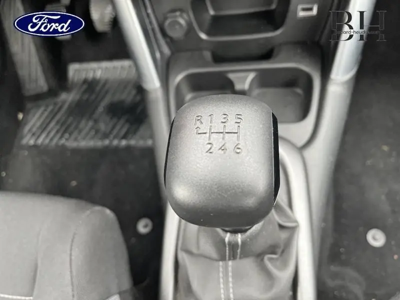 Le levier de vitesse manuel noir vu de dessus dans l'habitacle, avec indication des rapports en relief.