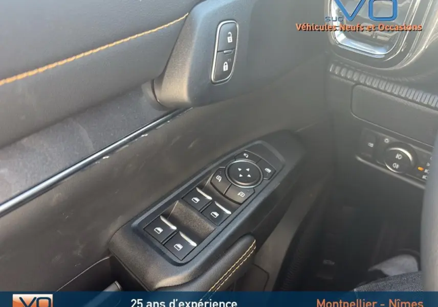 Gros plan sur les commandes des vitres électriques et verrouillage sur la porte côté conducteur du Ford Ranger noir 2025.