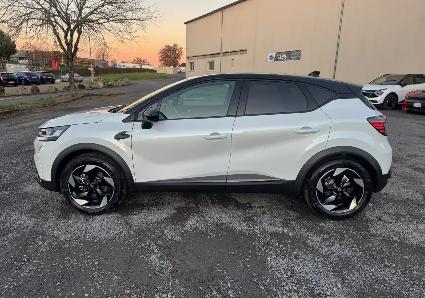 Vue de profil côté gauche du Renault Captur E-Tech blanc nacré avec toit noir et jantes noires au design moderne.