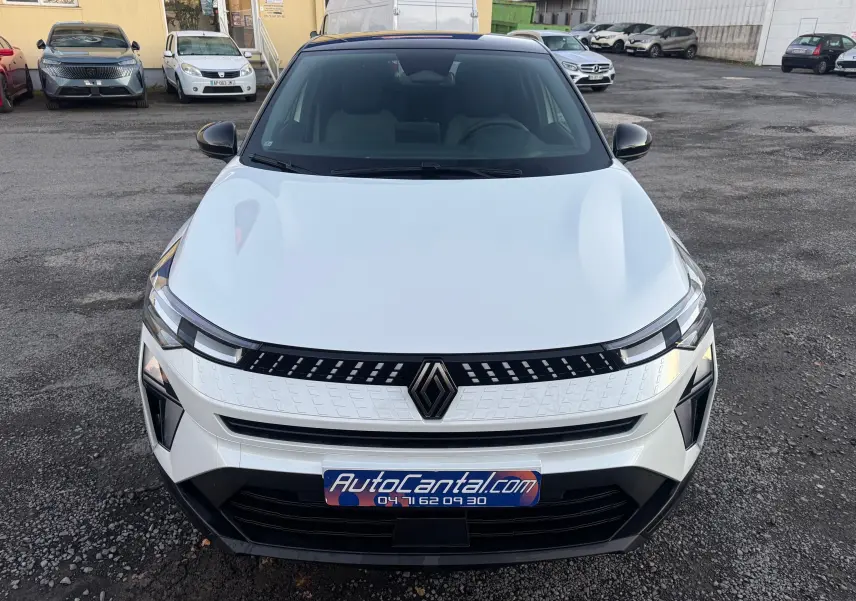 Vue avant d'un Renault Captur E-Tech Full Hybrid blanc nacré avec toit noir, mettant en valeur sa calandre moderne et ses phares LED.