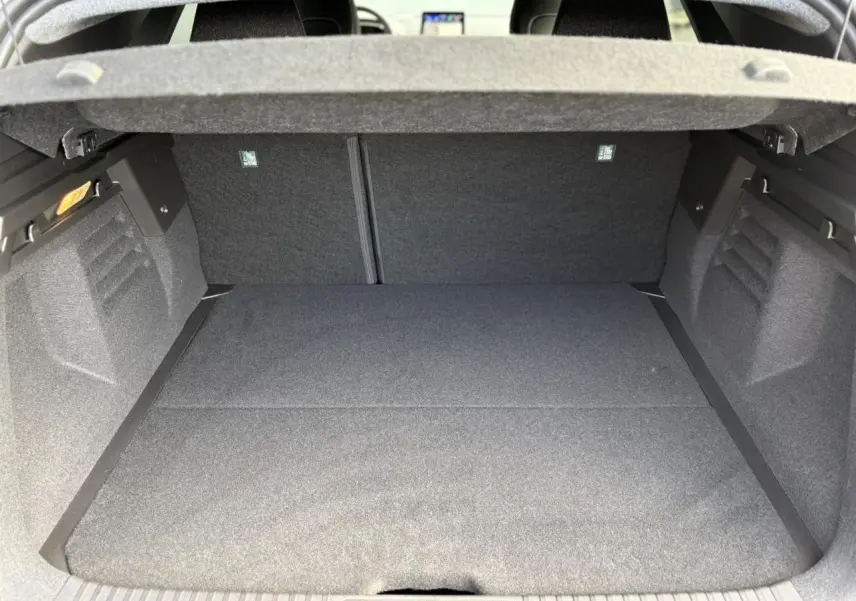 Coffre ouvert de la Renault Symbioz gris Rafale, montrant un espace de chargement propre et tapissé de tissu gris.