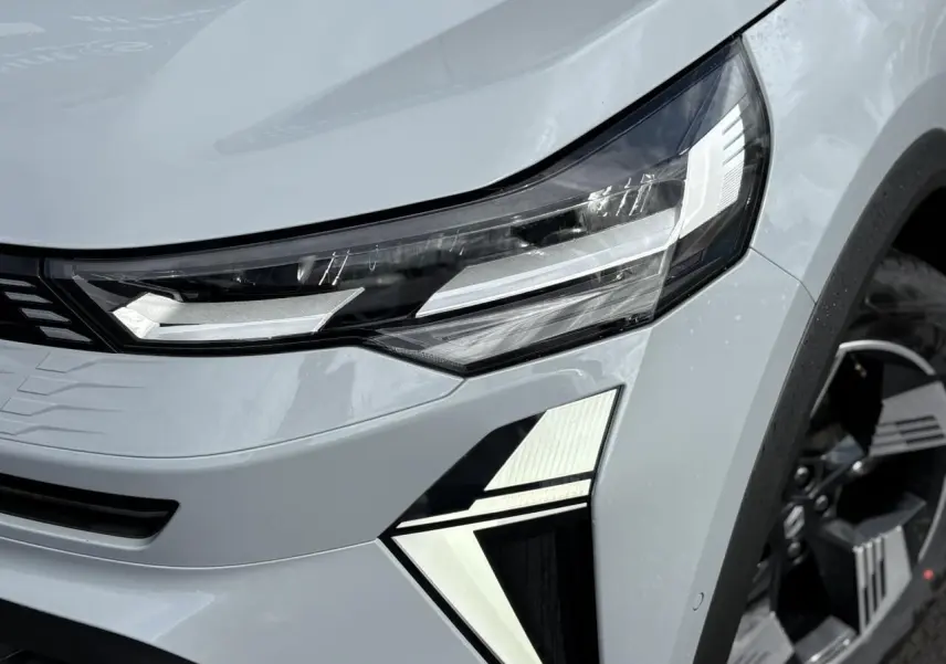 Gros plan sur le phare avant droit du Renault Symbioz gris Rafale avec signature lumineuse LED distinctive.