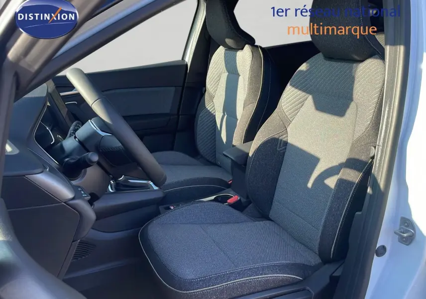 Intérieur du Renault Captur E-Tech Hybrid 2025, vue côté gauche sur sièges tissu gris et volant noir.