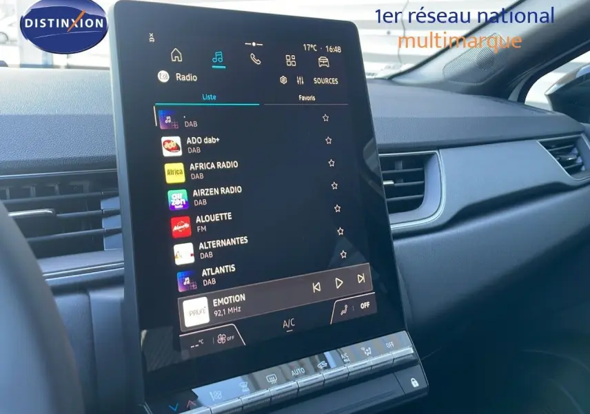 Écran tactile central du tableau de bord du Renault Captur E-Tech blanc nacré, affichant la liste des radios DAB.