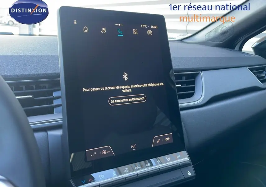 Écran tactile central du tableau de bord du Renault Captur E-Tech blanc nacré avec toit noir, vue intérieure côté passager.