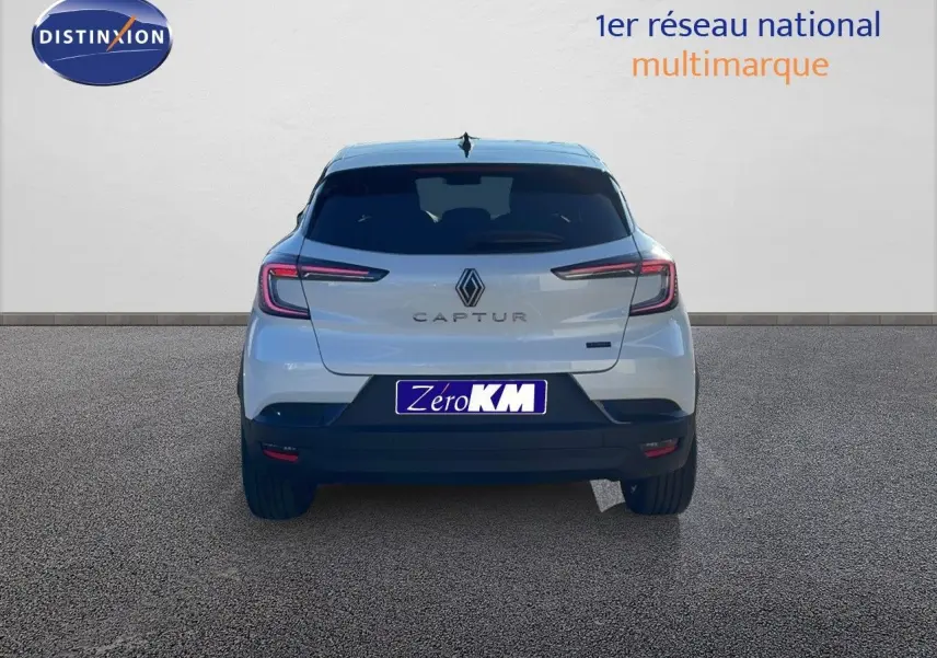 Vue arrière du Renault Captur E-Tech hybride blanc nacré avec toit noir, mettant en valeur ses feux LED fins et son logo central.