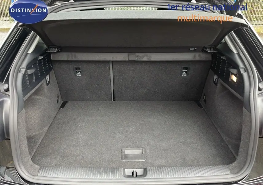 Coffre ouvert vu de l'arrière d'un Audi Q2 noir mito metal, montrant un espace de chargement propre et spacieux.