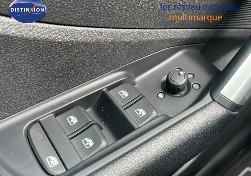 Gros plan sur les commandes de lève-vitres et réglage des rétroviseurs côté conducteur d’un Audi Q2 noir mito metal 2023.