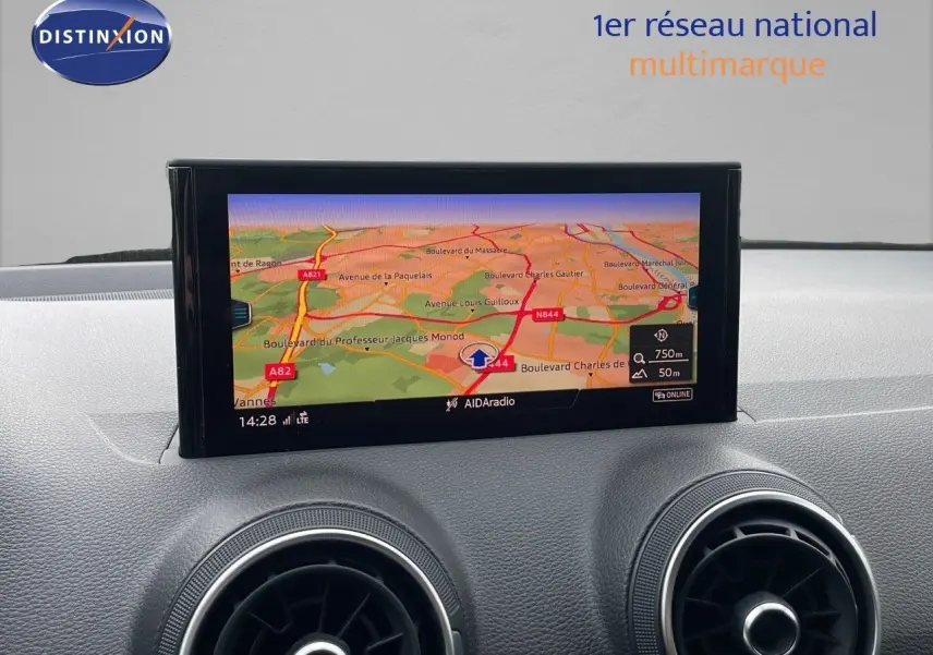 Vue avant rapprochée du tableau de bord de l'Audi Q2 noir mito metal avec écran GPS et aérateurs ronds.