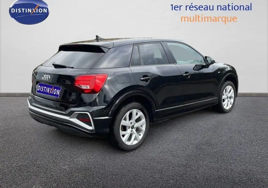 Audi Q2 noir mito metal en vue 3/4 arrière droit, mettant en valeur ses feux arrière et ses jantes argentées.
