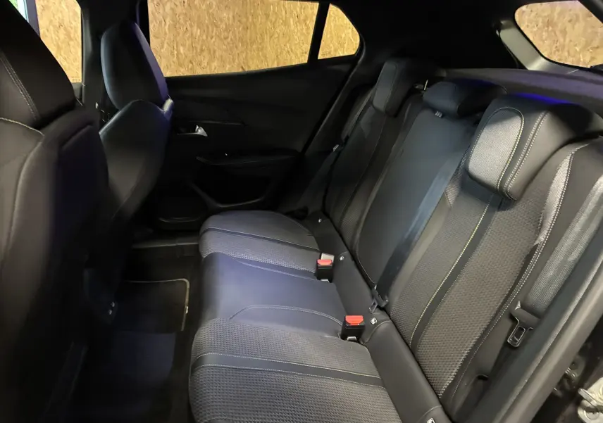 Vue intérieure du siège arrière côté droit du Peugeot 2008 noir, avec sellerie tissu noir et surpiqûres contrastantes.