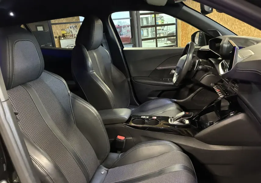 Intérieur noir du Peugeot 2008 1.5 BlueHDi 130 GT Line vu côté gauche, sièges en tissu et cuir avec console centrale moderne.