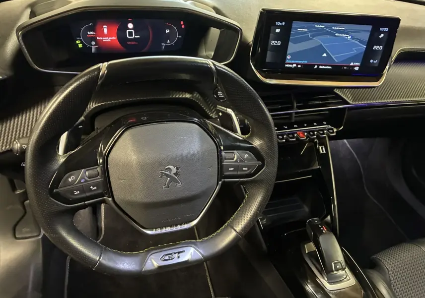Vue intérieure centrée sur le volant GT et le tableau de bord numérique du Peugeot 2008 noir avec écran tactile GPS.