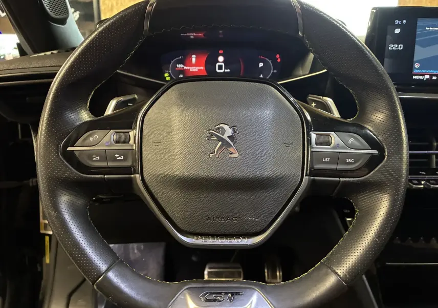 Vue rapprochée du volant cuir noir perforé du Peugeot 2008 GT Line 2020 avec commandes intégrées et logo central lion.