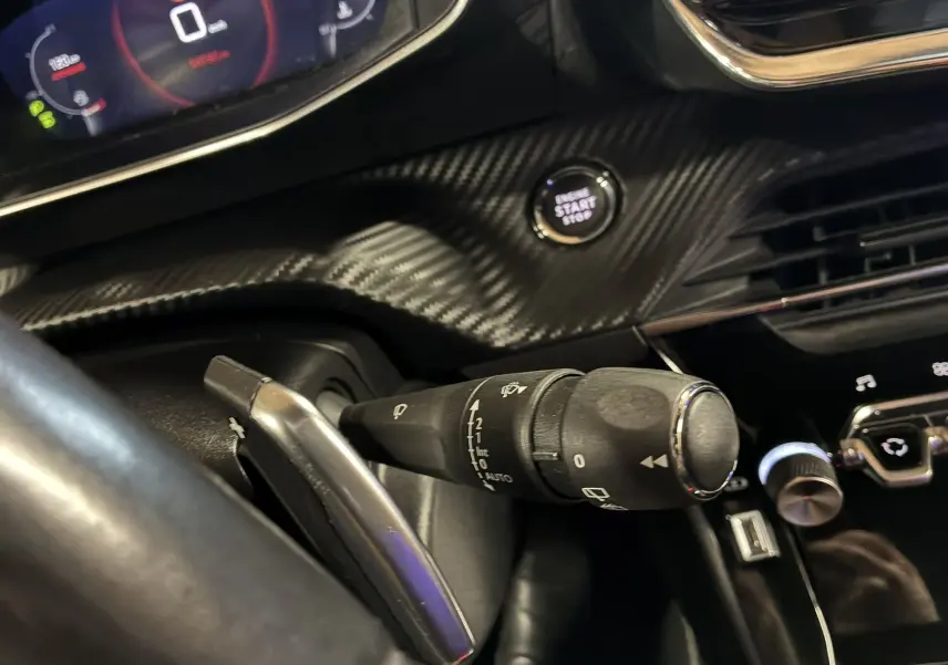 Gros plan sur la commande d'essuie-glace et le bouton start/stop dans l'habitacle noir du Peugeot 2008 GT Line 2020.