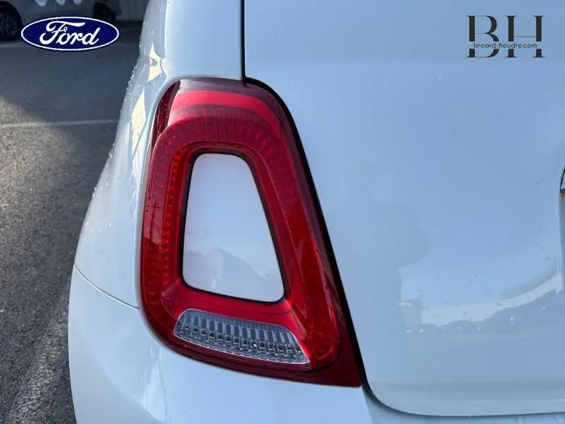 Gros plan sur le feu arrière gauche d'une FIAT 500 blanche Bossa Nova Pastel, mettant en valeur sa forme distinctive.