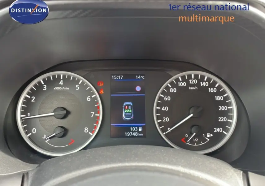 Tableau de bord du Nissan Juke 2023 avec compte-tours, compteur de vitesse et écran central affichant la consommation et la température.