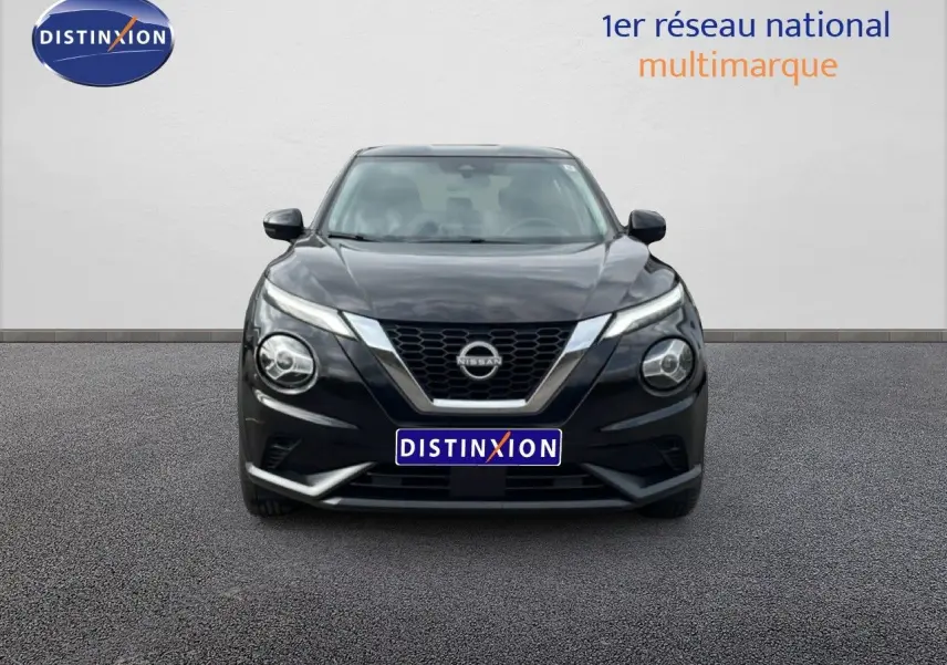 Vue frontale d'un Nissan Juke noir perle métal 2023 avec calandre en V chromée et phares ronds distinctifs.