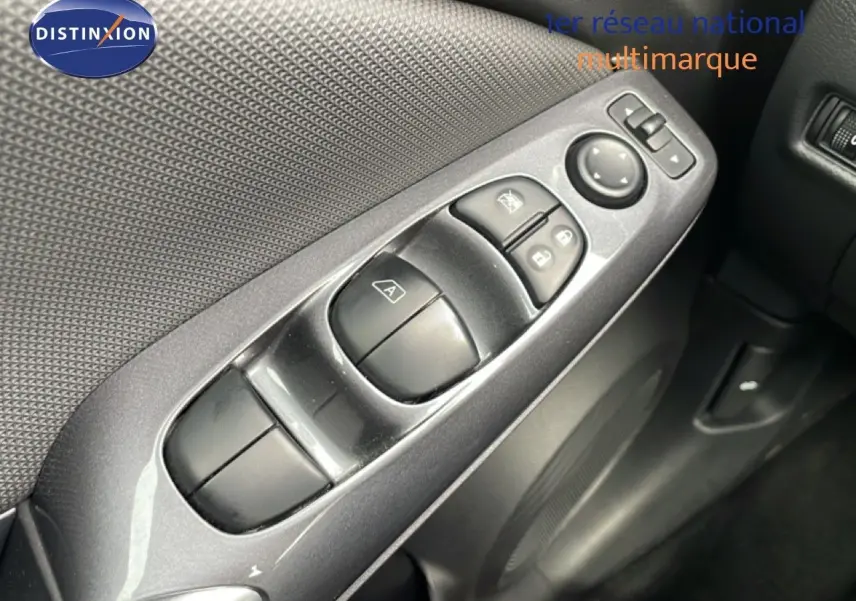 Vue rapprochée des commandes de lève-vitres et rétroviseurs sur la porte intérieure d'une Nissan Juke noire perle métal.