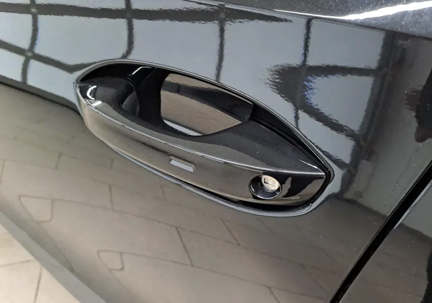 Gros plan sur la poignée de porte côté gauche du CUPRA Formentor 1.4 e-HYBRID noir minuit avec serrure intégrée.