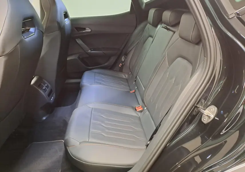 Vue intérieure côté arrière droit de la CUPRA Formentor 1.4 e-HYBRID 2023 avec sièges baquets cuir noir et surpiqûres copper.