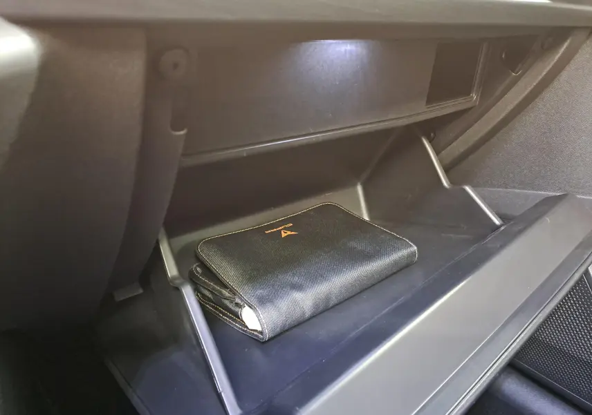 Gros plan sur la boîte à gants ouverte du CUPRA Formentor 2023 avec pochette noire et surpiqûres copper visible.