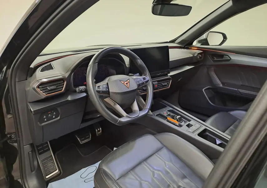 Vue intérieure côté conducteur du CUPRA Formentor noir Minuit 2023, avec volant multifonction et sièges cuir noirs surpiqués cuivre.