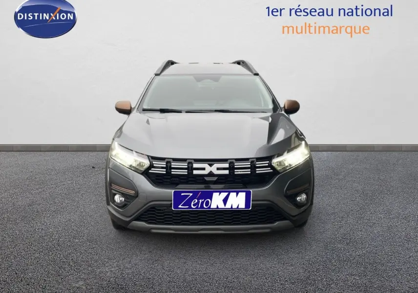 Vue avant d'un Dacia Jogger gris schiste métallisé avec feux allumés et calandre noire distinctive.