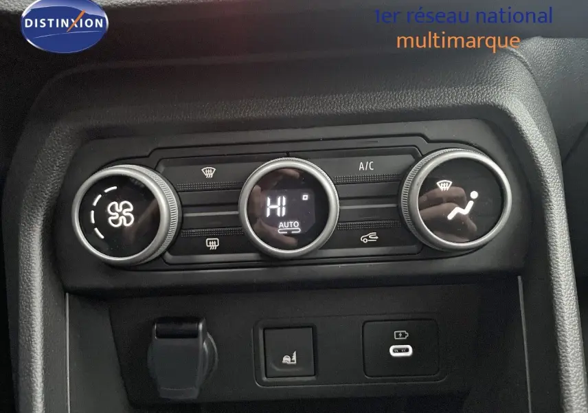 Gros plan sur la commande de climatisation automatique du Dacia Jogger gris schiste, avec affichage digital et boutons rotatifs.