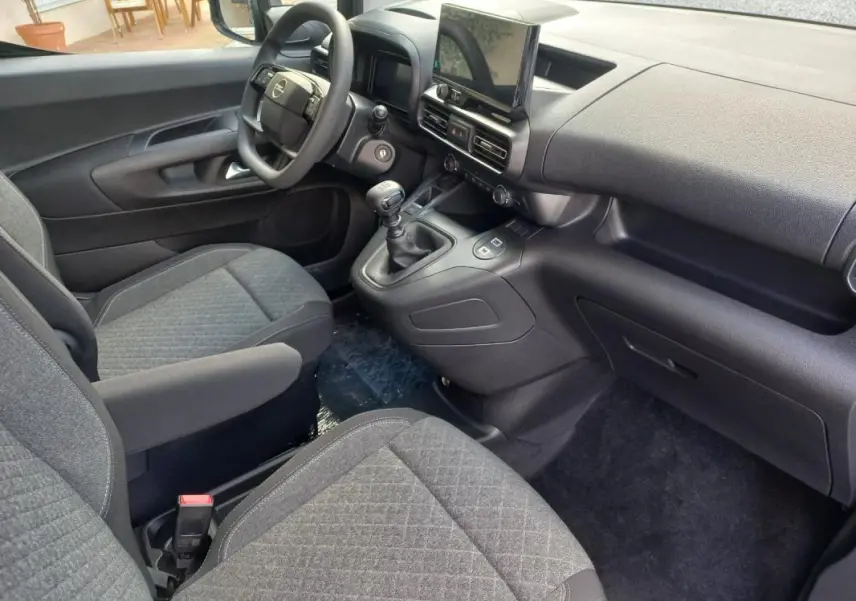 Vue intérieure côté conducteur de l’Opel Combo LIFE Elegance M 2025, avec tableau de bord noir et sièges gris.